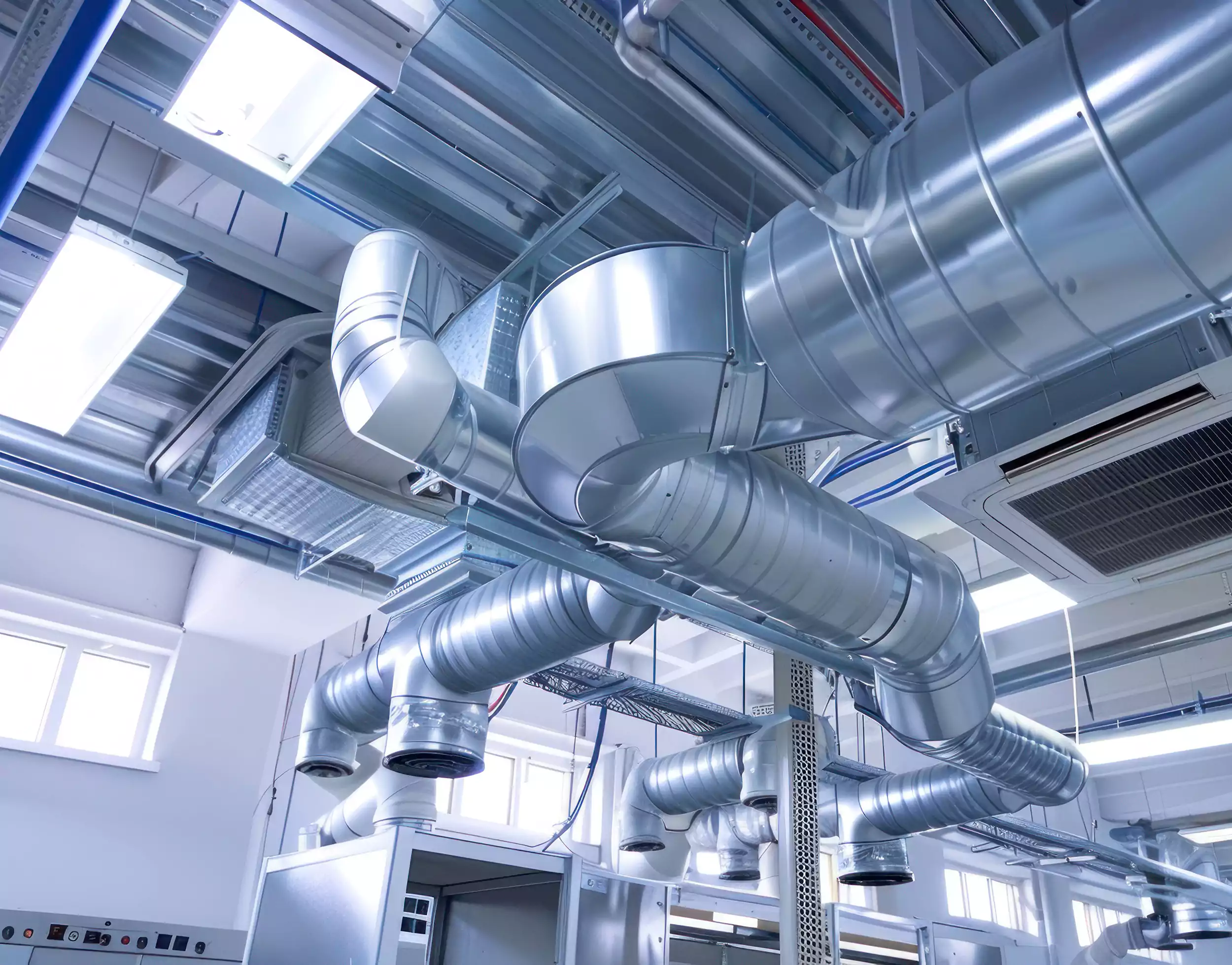 Exposed spiral ductwork and air distribution running below a commercial ceiling