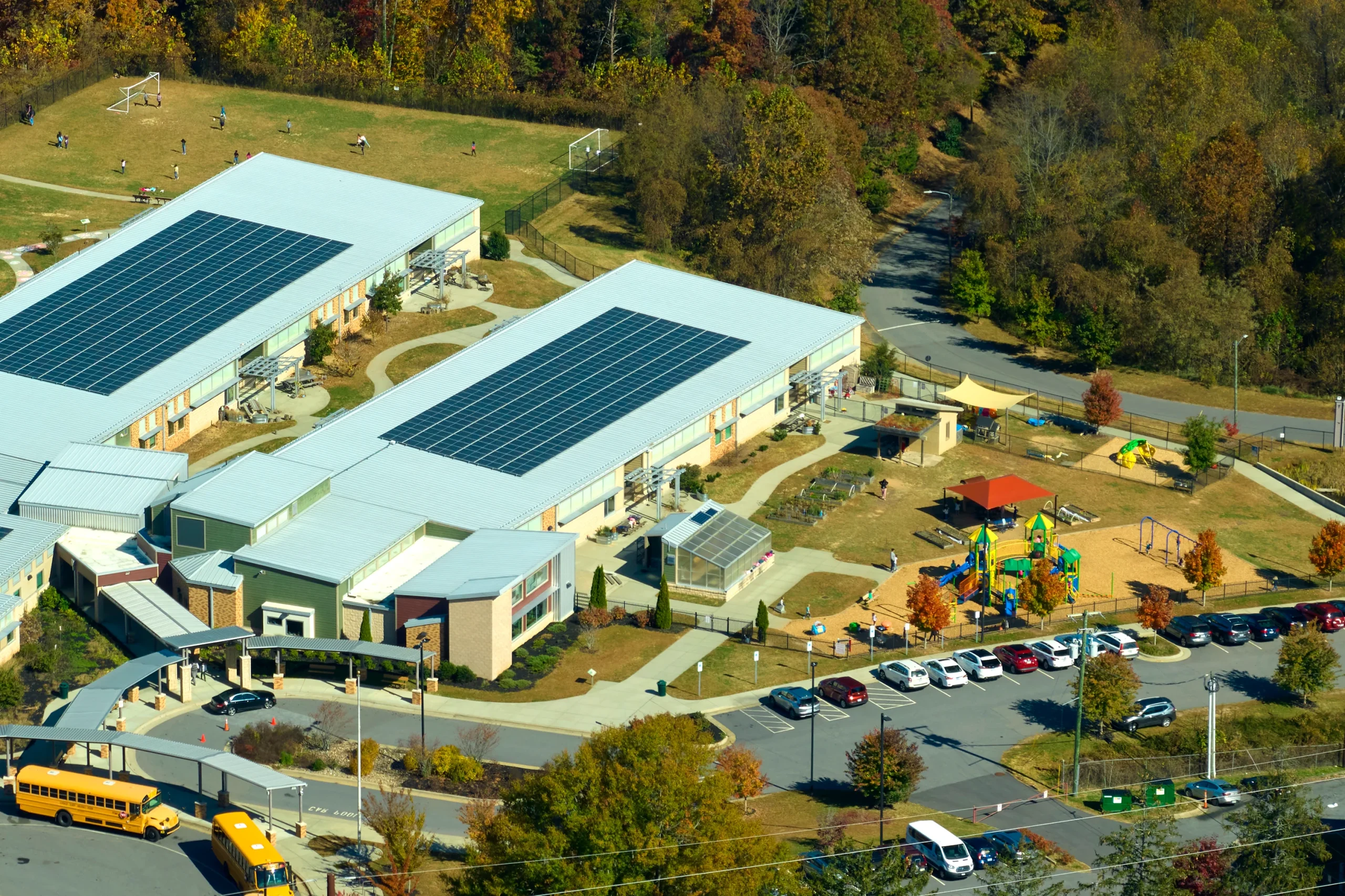 Aerial view of a school campus with photovoltaic arrays covering the rooftops
